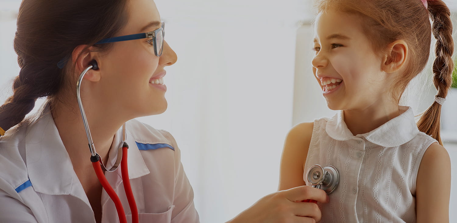 Smiling pediatrician checking a happy girl.